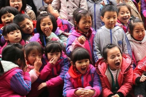 吊るされ、内臓が飛び出るブタを見て喜ぶ子供たち　中国