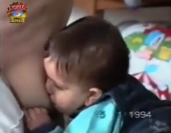 逆立ちをしてるママのおっぱいを吸う赤ん坊